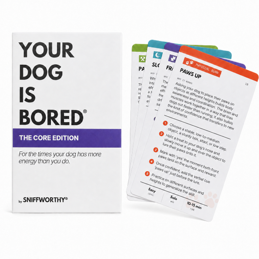 A boxed dog training card set titled "YOUR DOG IS BORED: THE CORE EDITION" by Sniffworthy, shown with several cards fanned out beside the box on a white background.