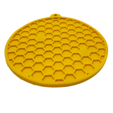 Yellow silicone mat with honeycomb pattern on a white background