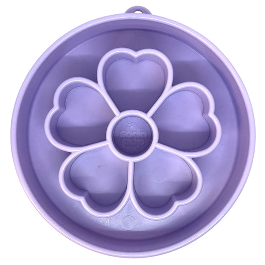 A lavender purple pet slow feeder bowl with a flower-shaped center and five heart-shaped compartments, shown from a top-down view on a white background.