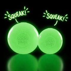 Two glow-in-the-dark SodaPup Squeak Balls glowing green